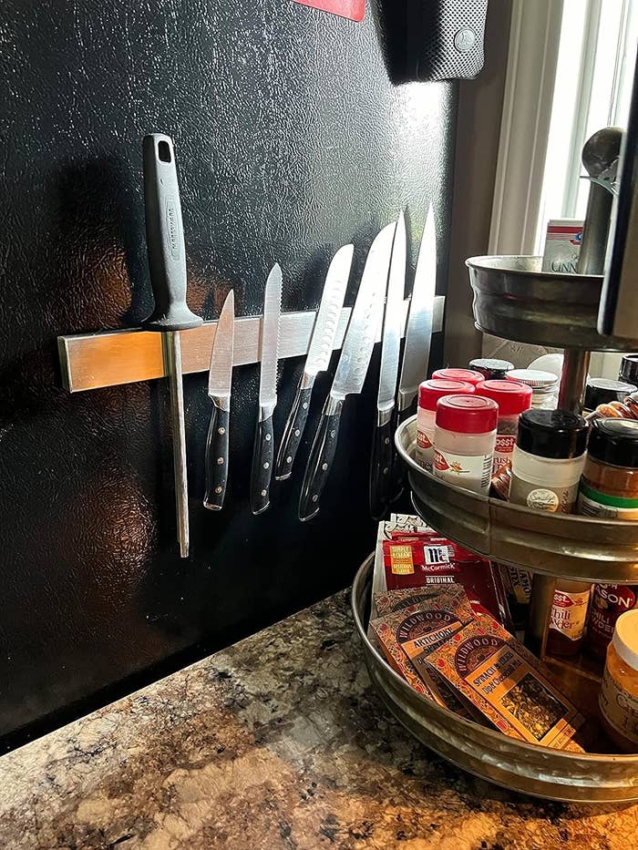 the double-sided magnetic knife holder on the side of fridge