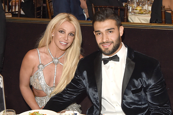 Britney Spears sits at a table with Sam Asghari and holds his hand
