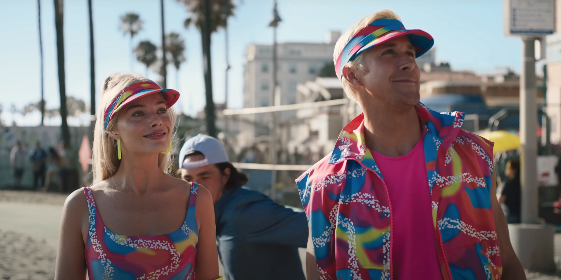 Margot Robbie and Ryan Gosling as Ken rollerblading on the boardwalk in matching outfits and visors in a scene from &quot;Barbie&quot;