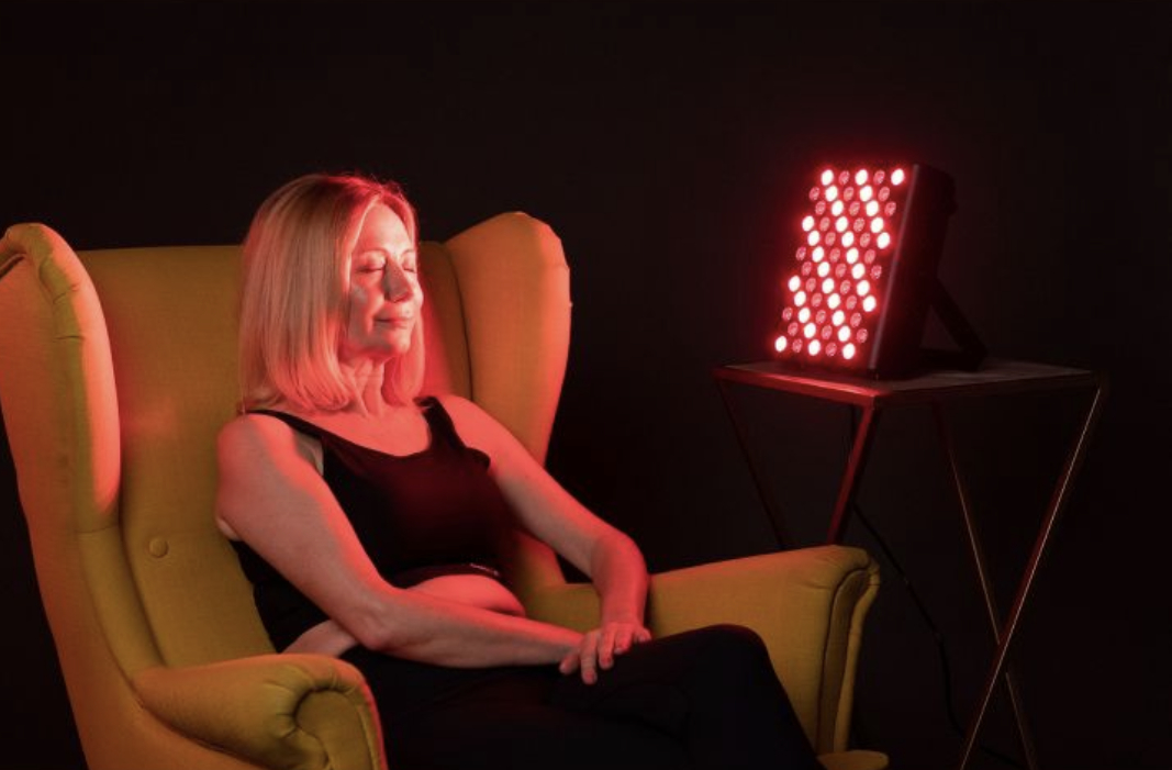 A model in front of the infrared light therapy device