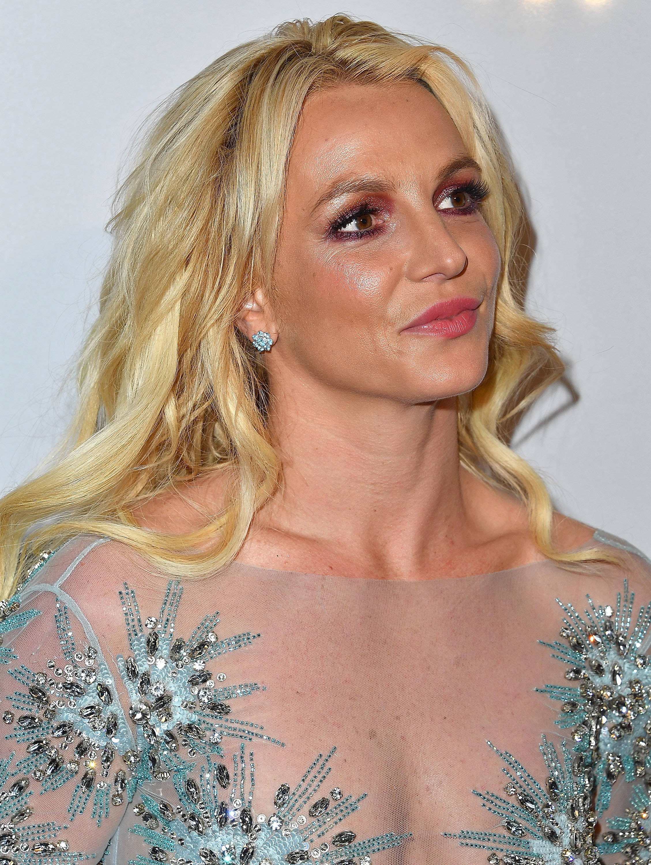 Close-up of Britney at a media event, wearing a sparkly outfit