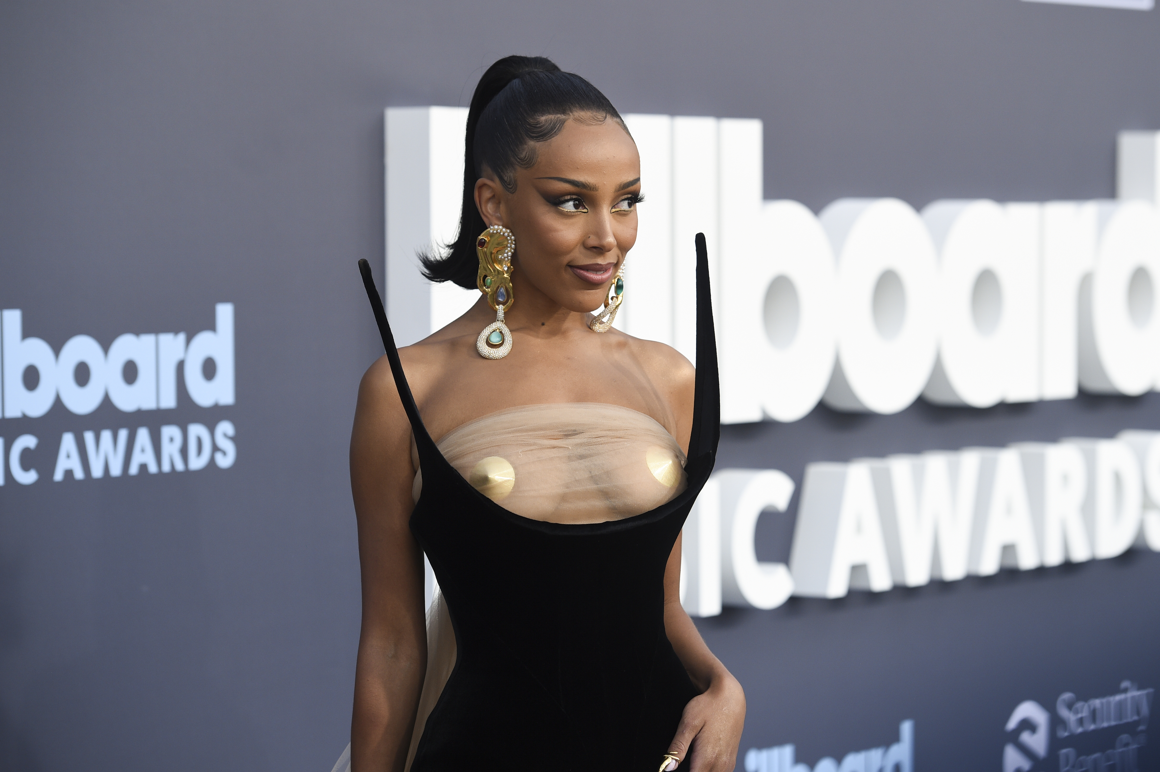 Doja on the Billboard awards red carpet in a architectural strapless dress with a see-through top