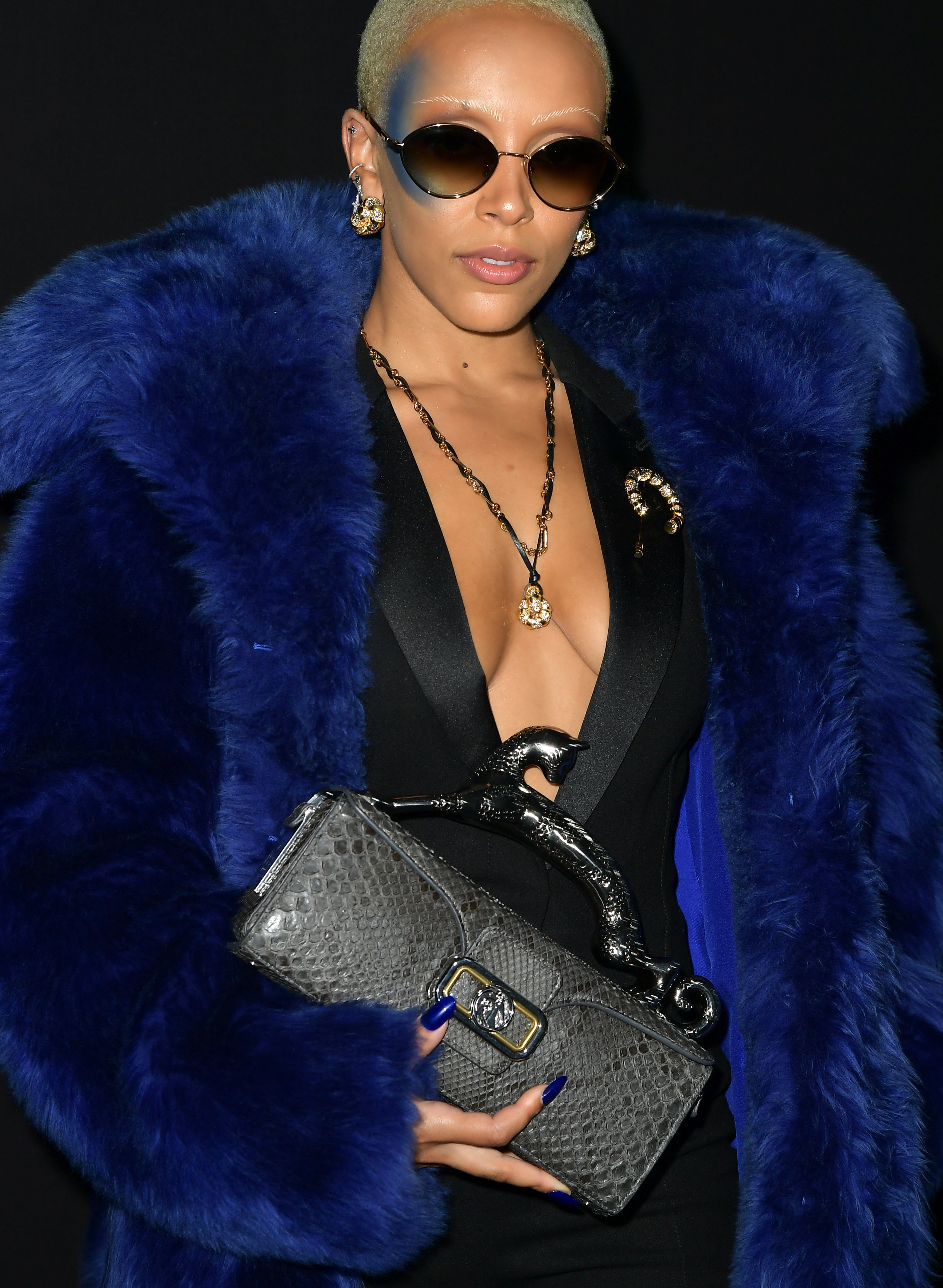 A close-up of Doja wearing sunglasses and a furry coat