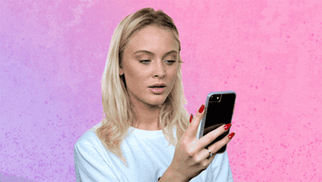 GIF of Zara Larsson looking at her phone