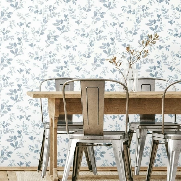 Blue and white floral wallpaper in a farmhouse-style dining room with a wood table and metal chairs