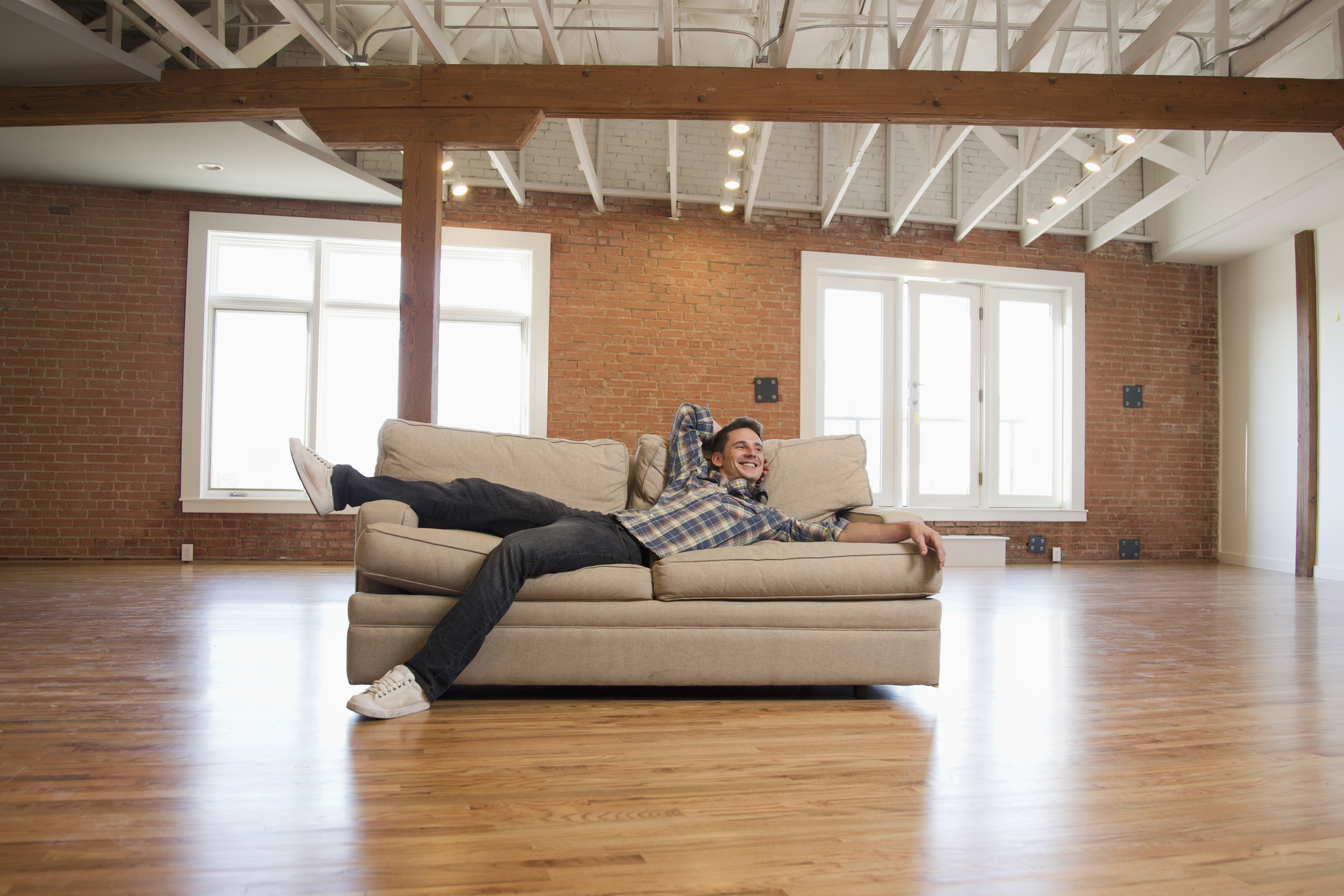 man sitting on a couch in otherwise empty space