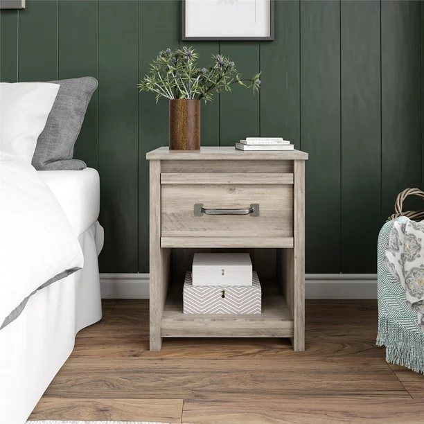 White washed nightstand in front of a dark green paneled wall