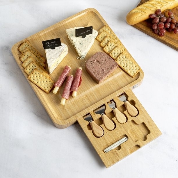 A charcuterie board with a pull out drawer