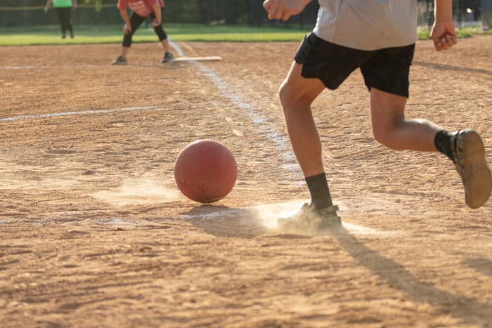 A kid playing kickball