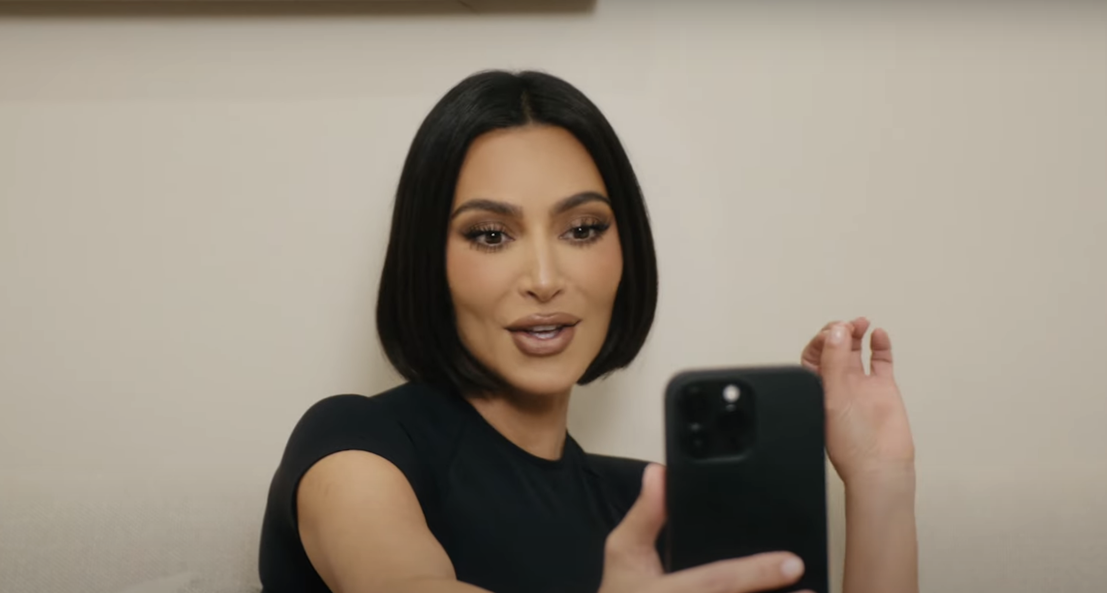 Kim with the bob looking at her phone