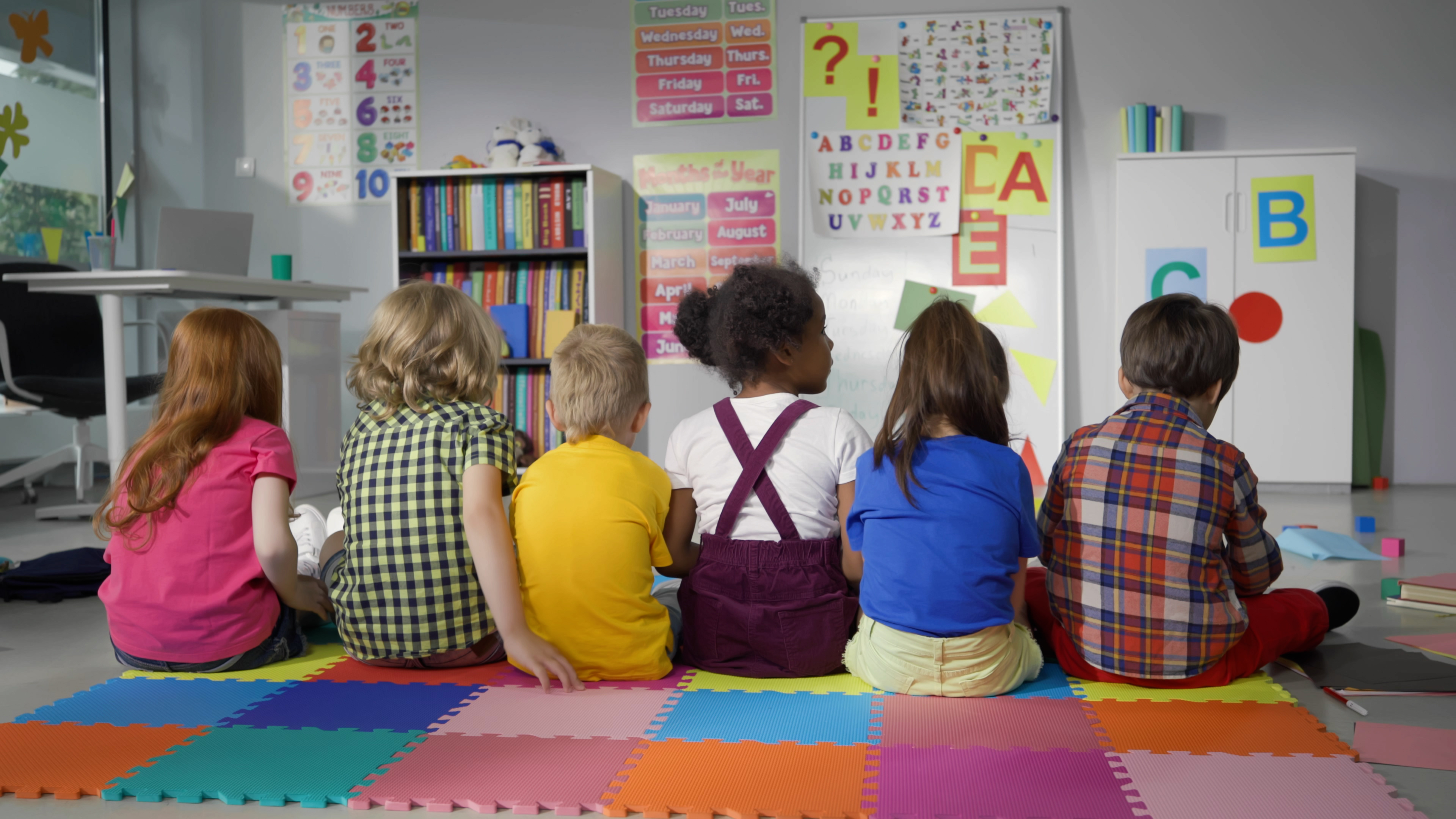 Young children sitting on the floor of a classroom