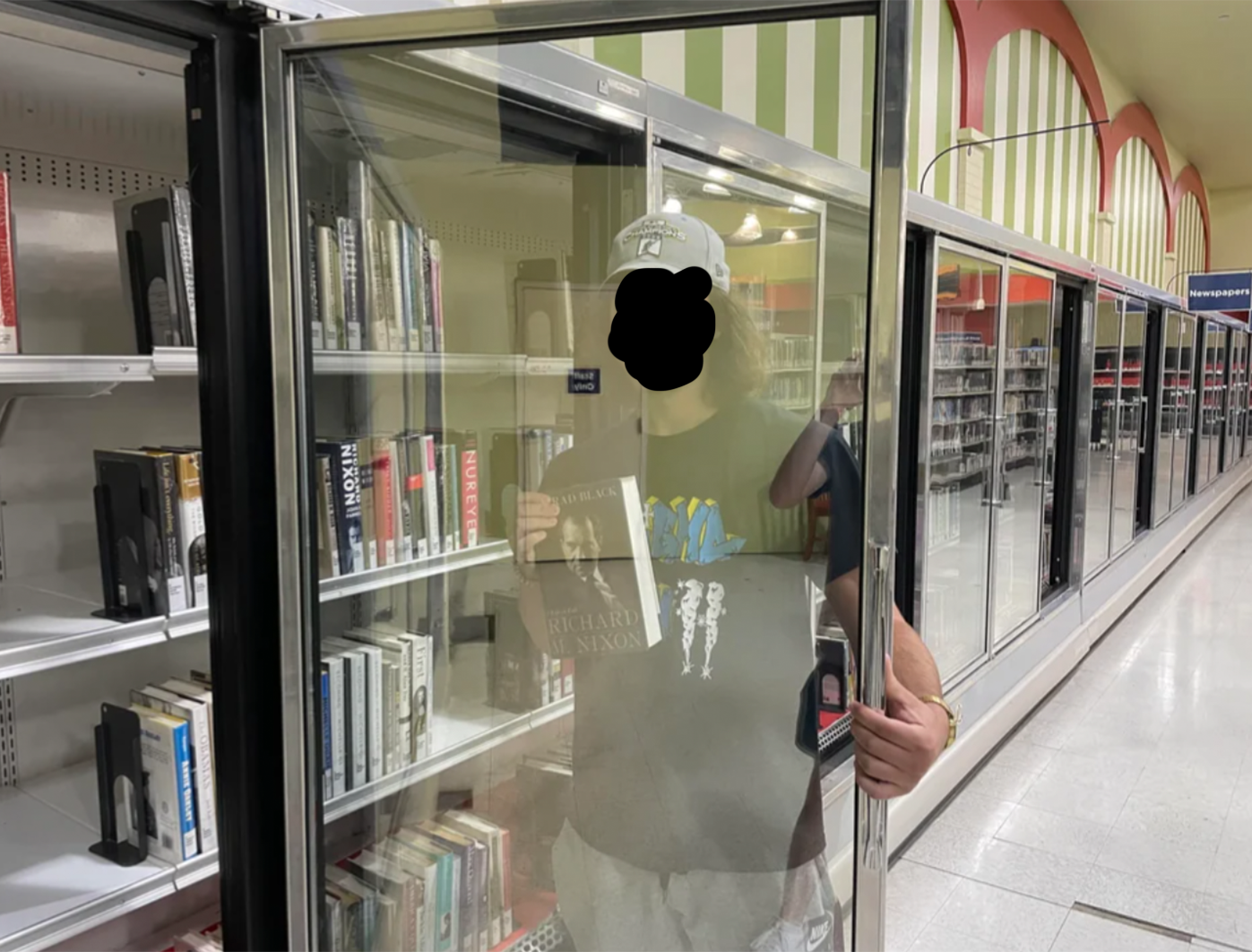 person grabbing a book from an old frozen section