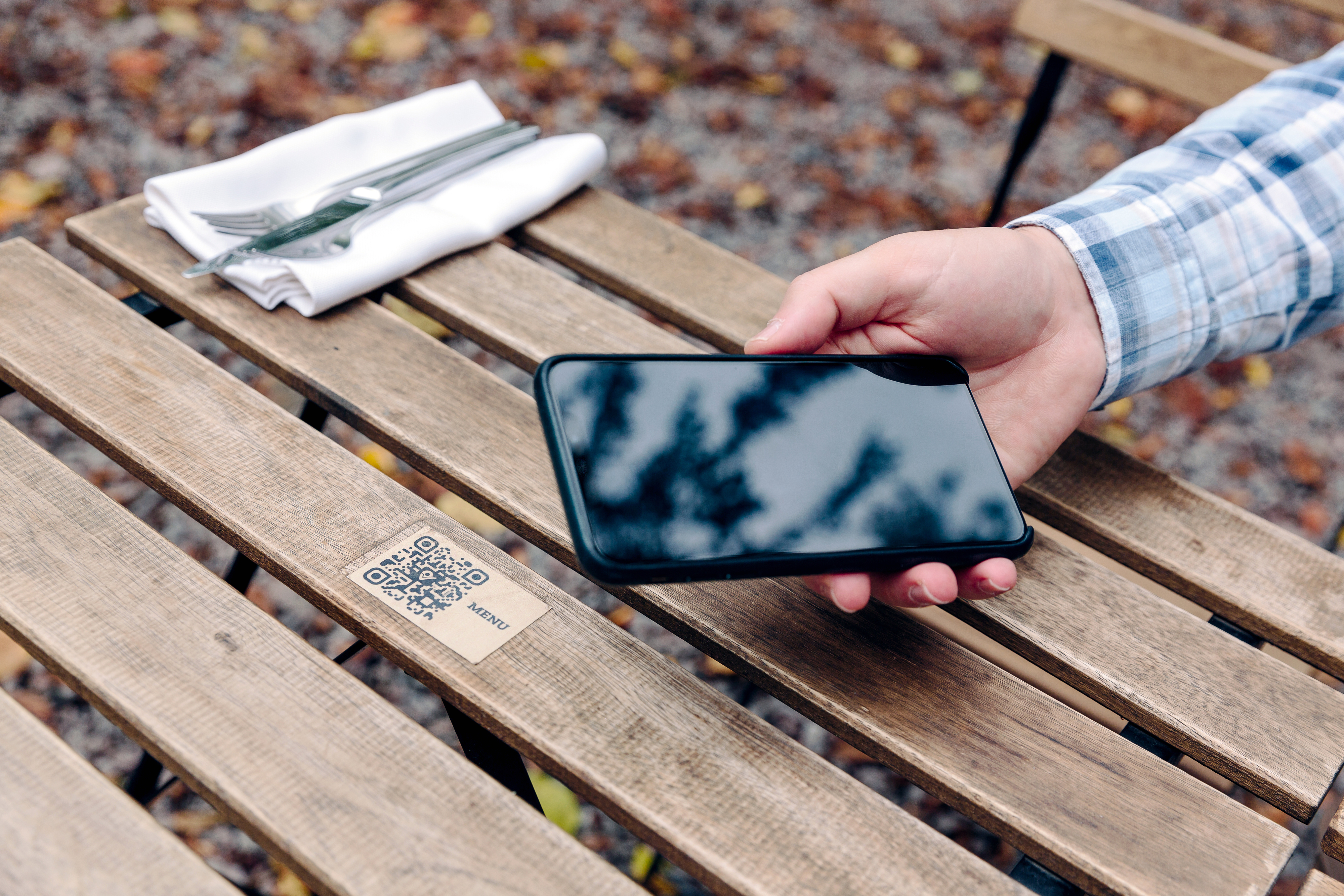 a person holding their cell phone up to a QR code