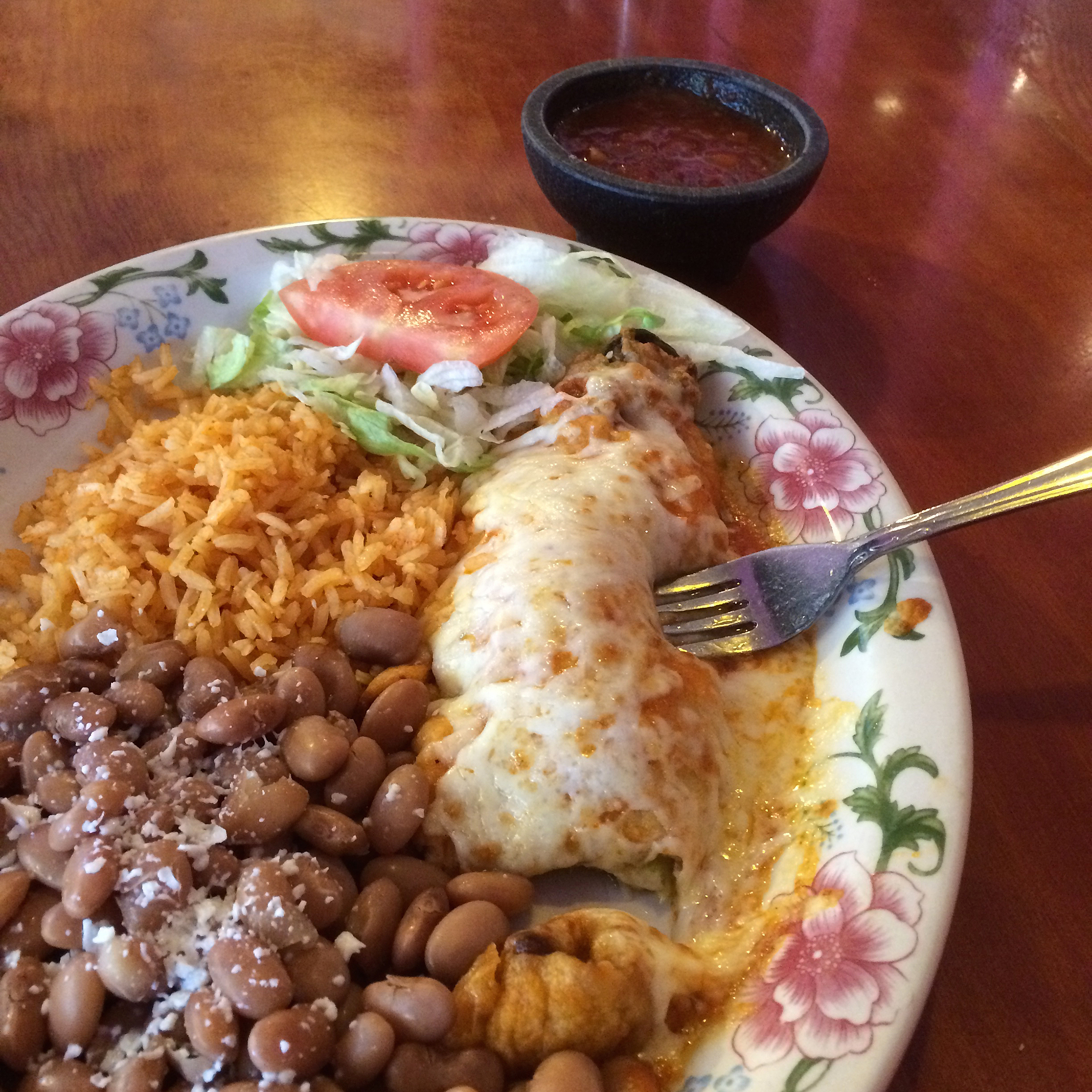 plate of beans, rice, and enchilada at a restaurant
