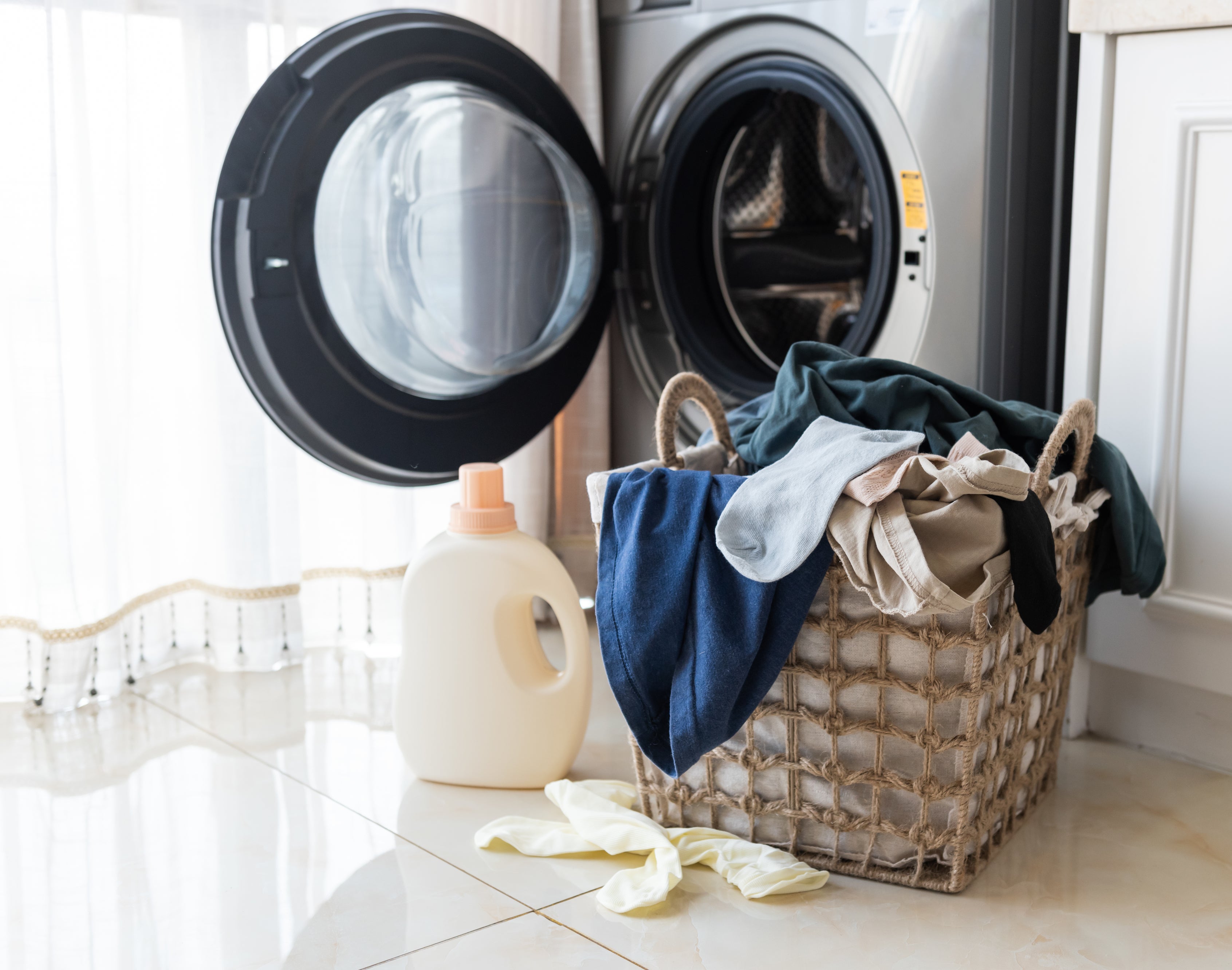 A basket of laundry in front of a washing machine