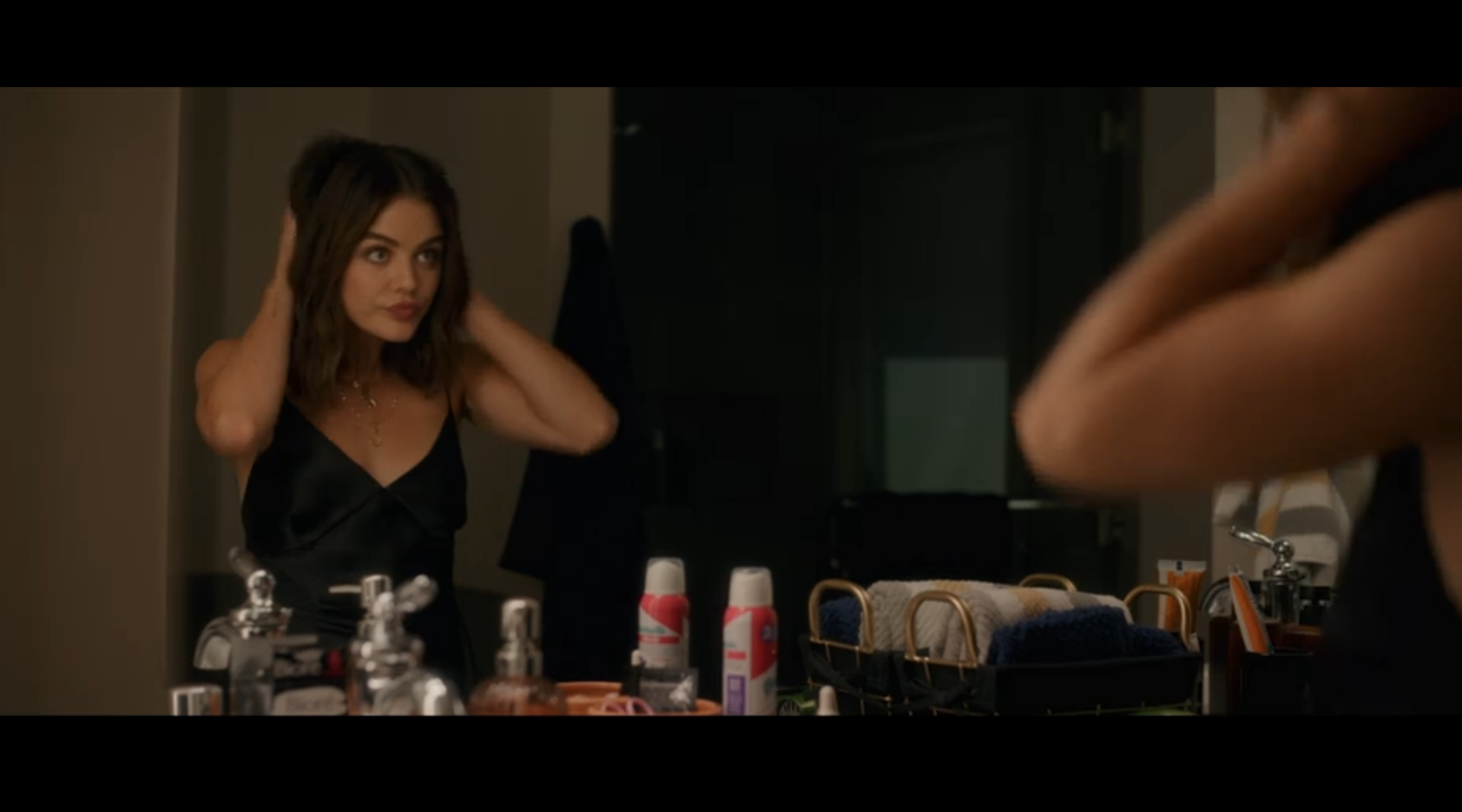 lucy hale fluffing hair in mirror, dressed up to go out