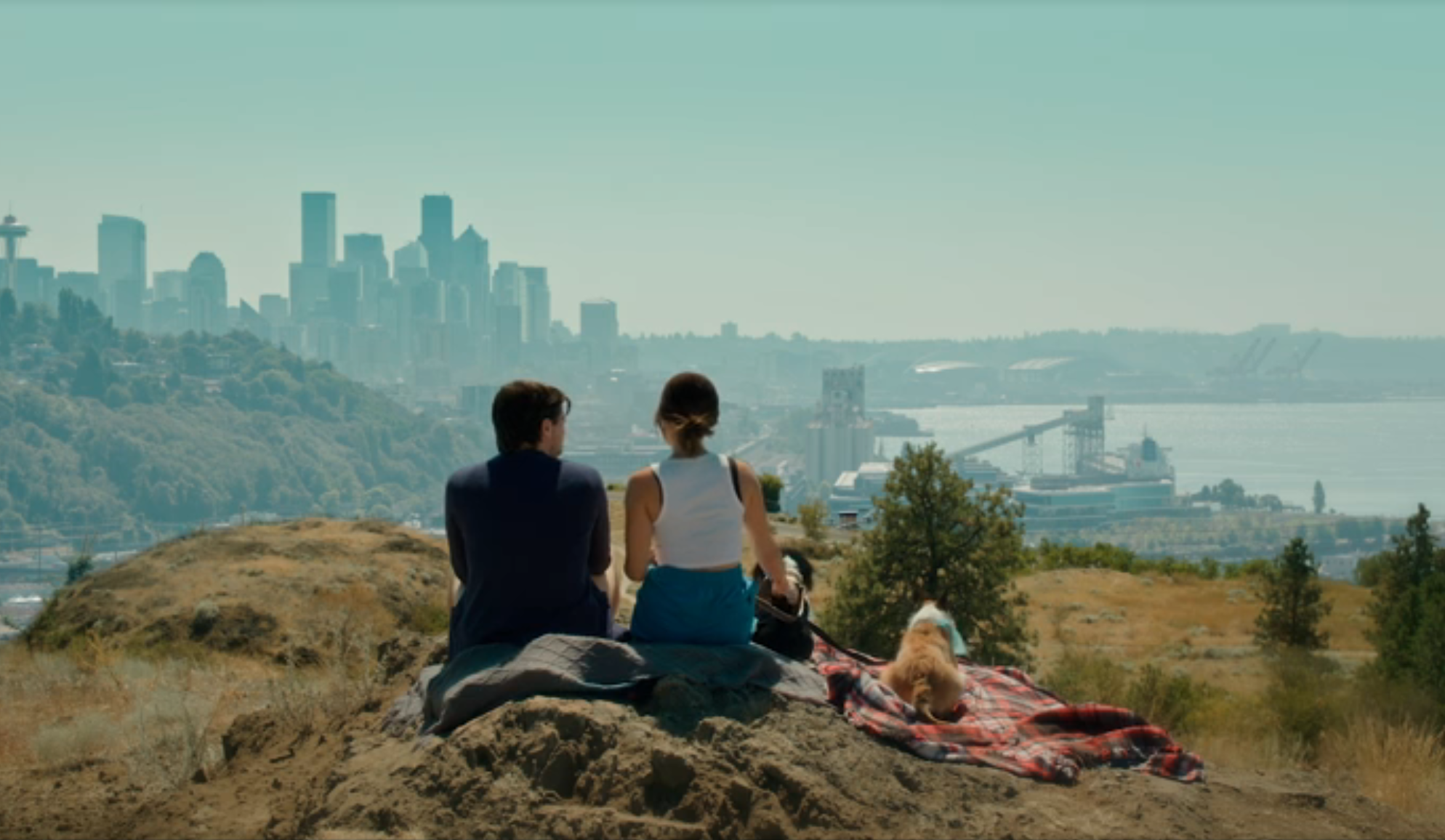 lucy hale and grant gustin having picnic with dogs at top of hill overlooking city