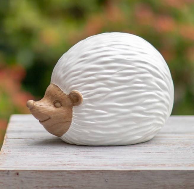 The hedgehog has a white body and a faux carved wood-look face