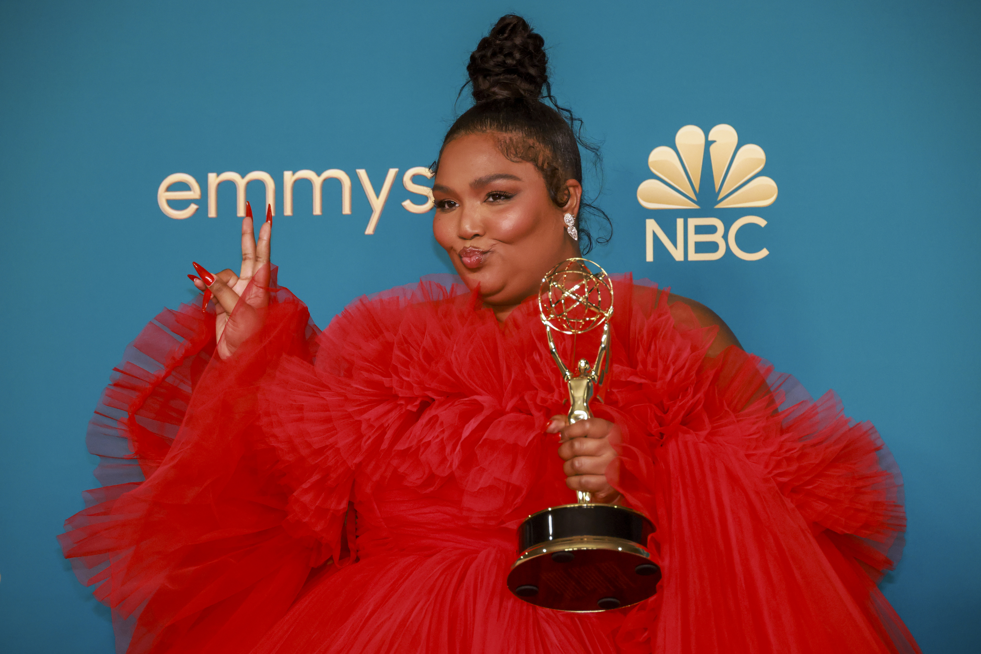 Closeup of Lizzo holding her Emmy award