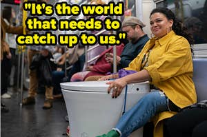 Michelle Buteau as Mavis sitting on the subway holding a toilet in front of her from "Survival of the Thickest"