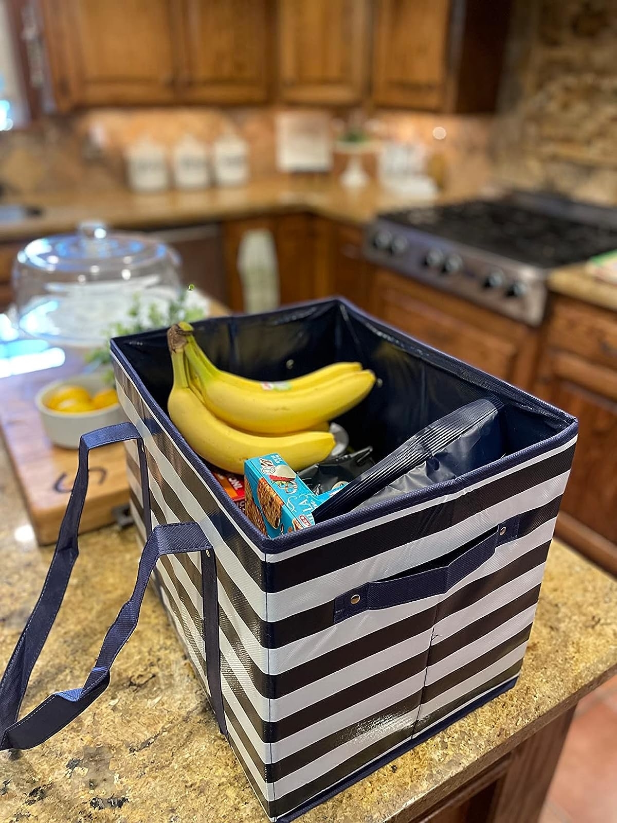 Reviewer image of the striped bag with groceries in it on their countertop