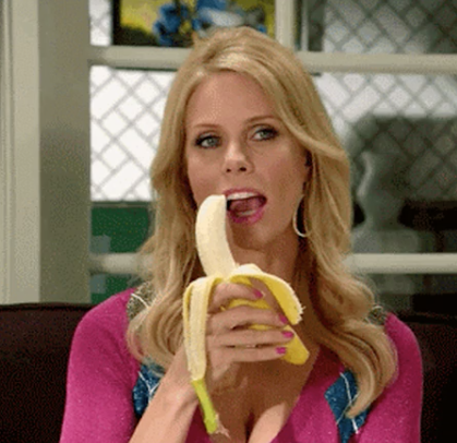 A woman about to put a banana in her mouth
