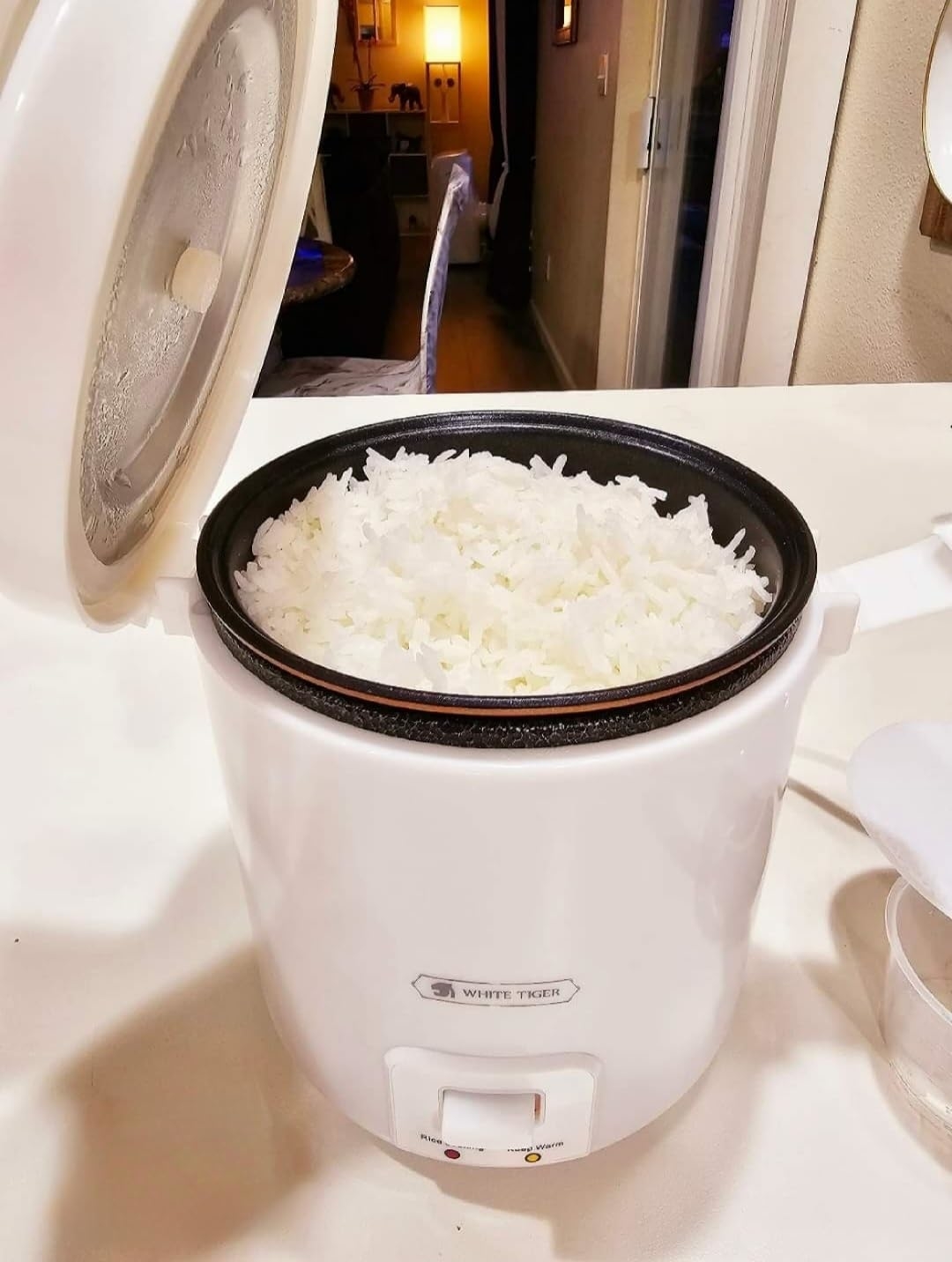 Reviewer image of the white rice cooker with cooked rice inside it