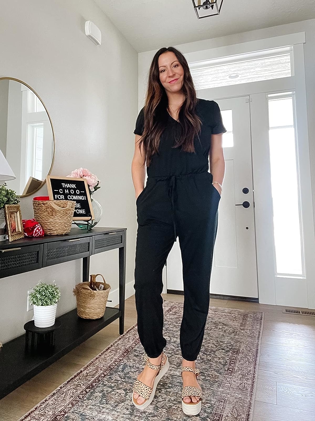 Reviewer wearing the black jumpsuit with platform sandals