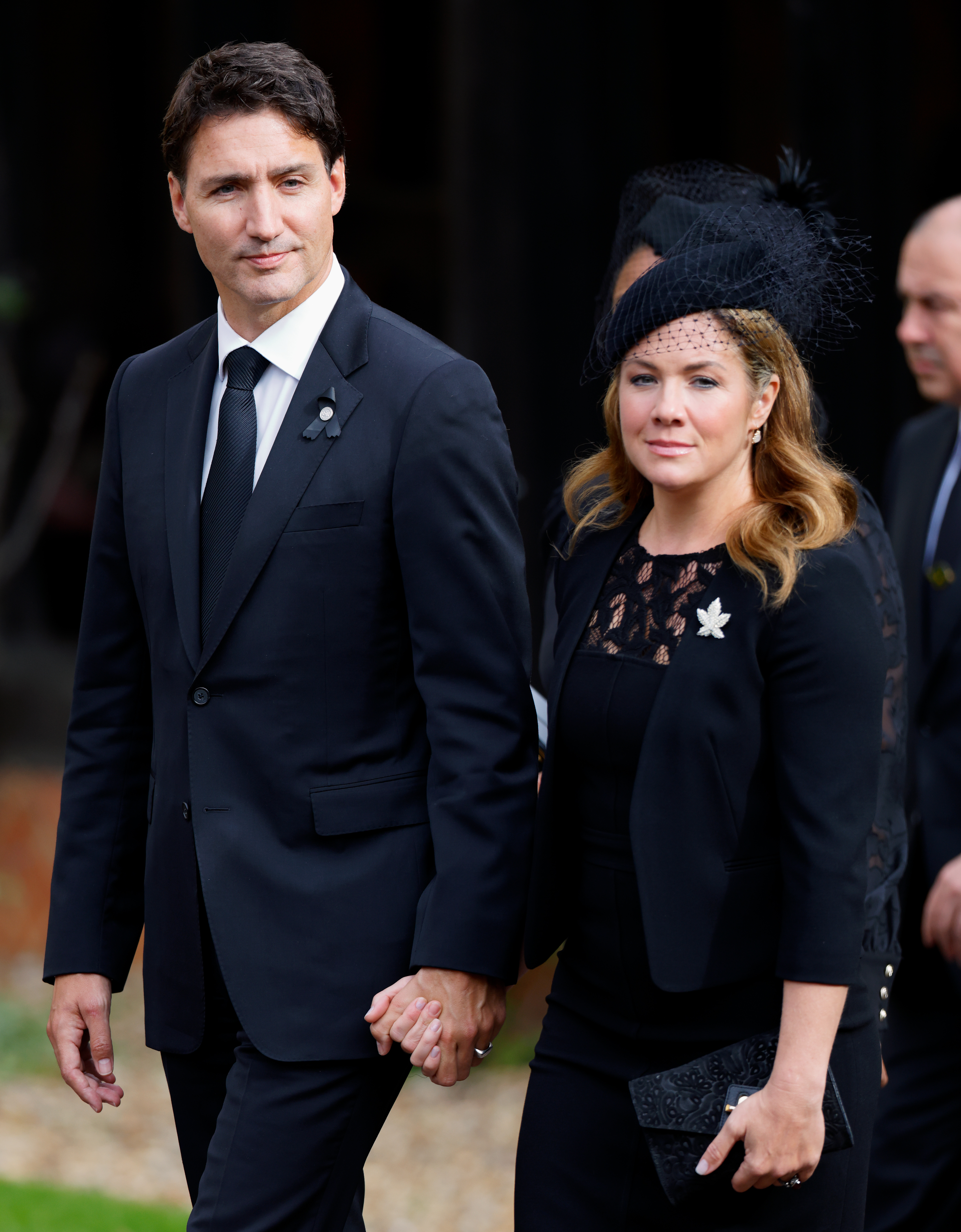 closeup of the two arriving to an event holding hands