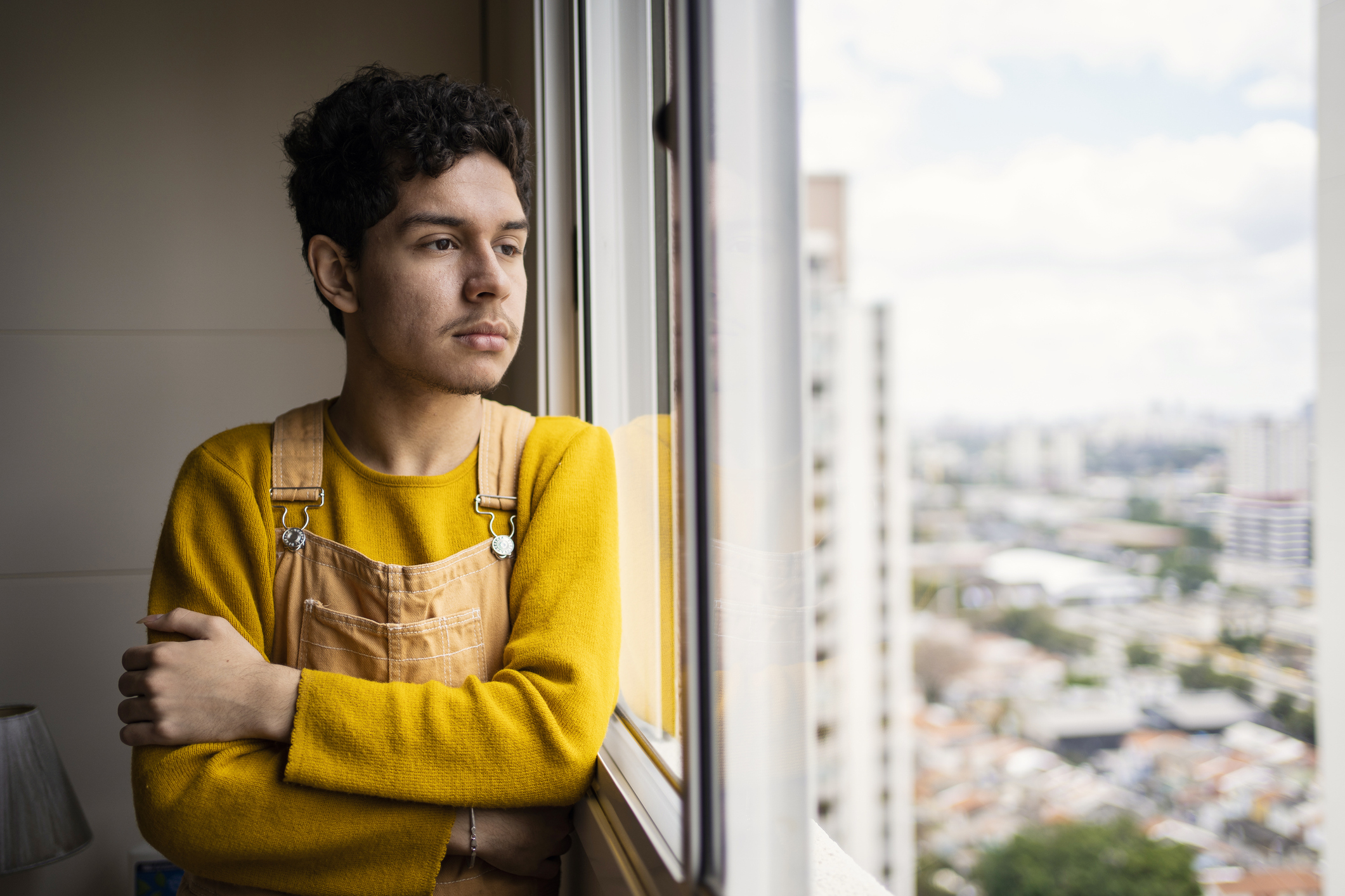 A young man staring out a window