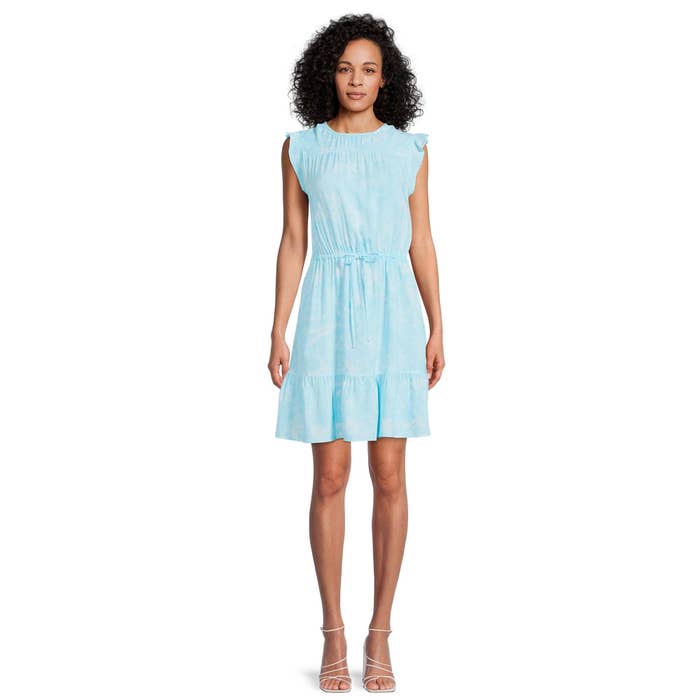 model wearing sleeveless blue flutter sleeve dress