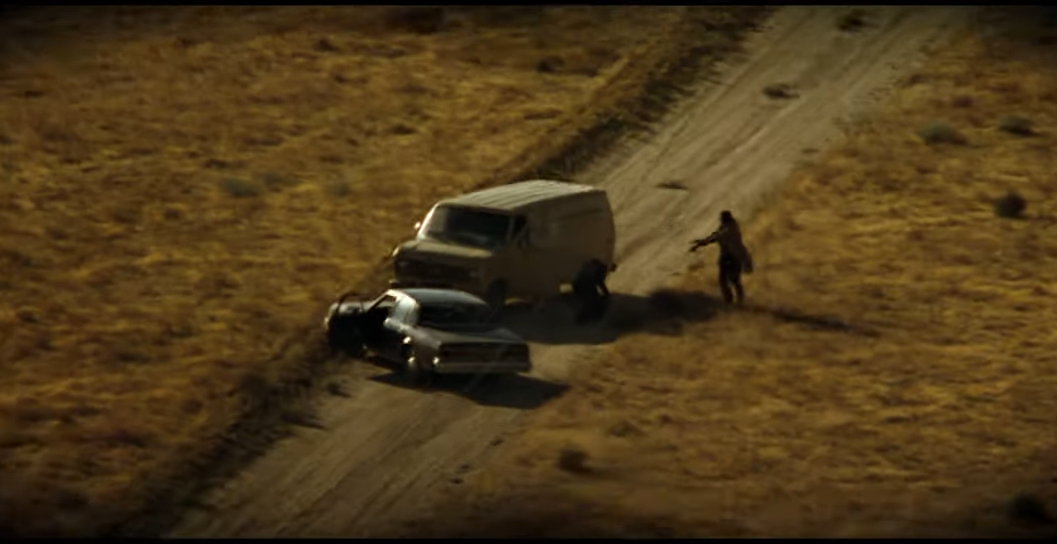 A helicopter point of view of a van approaching brad pitt and morgan freeman in Seven