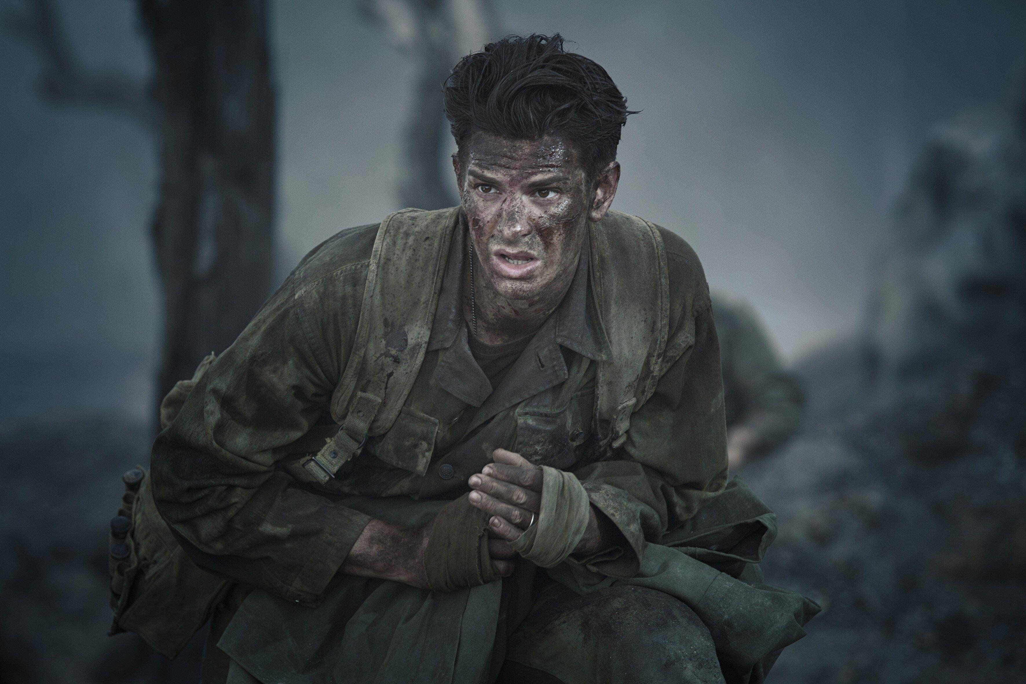 Andrew Garfield sneaks around the trenches of World War II while covered in soot and dirt