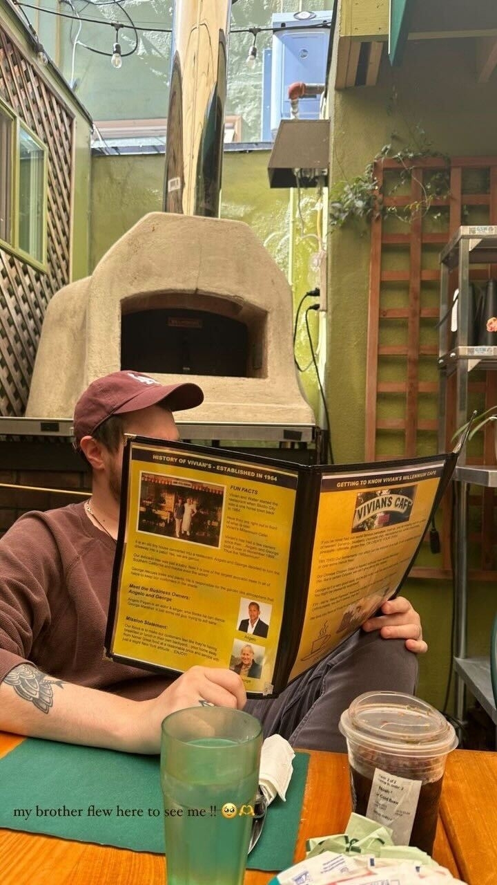 Braison reading a menu with a caption on the photo saying &quot;My brother flew here to see me&quot;