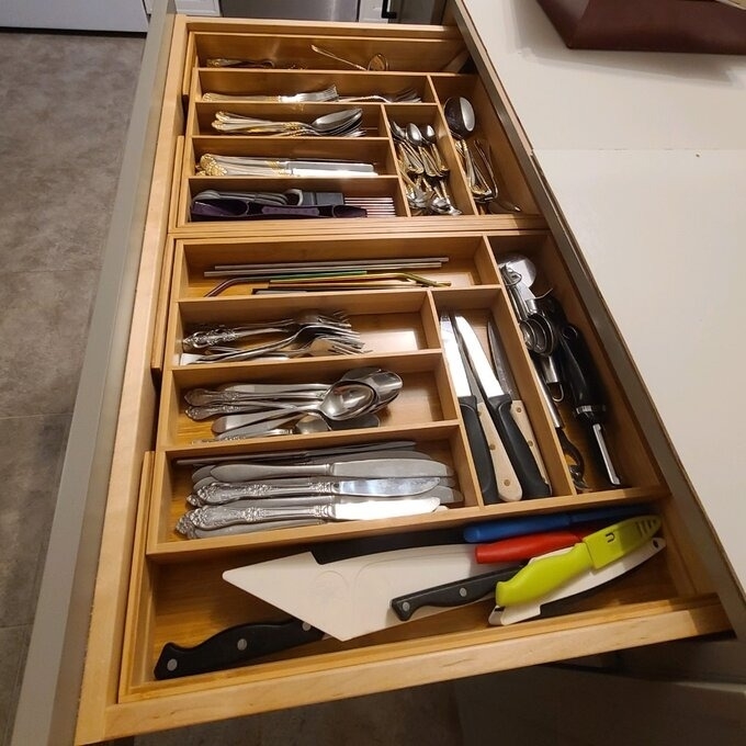 A user&#x27;s wooden silverware organizer in a drawer.