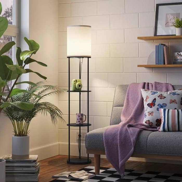 black shelf lamp with three shelves in living room corner