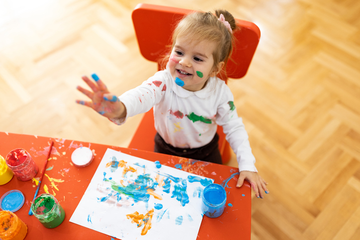 A young child covered in paint