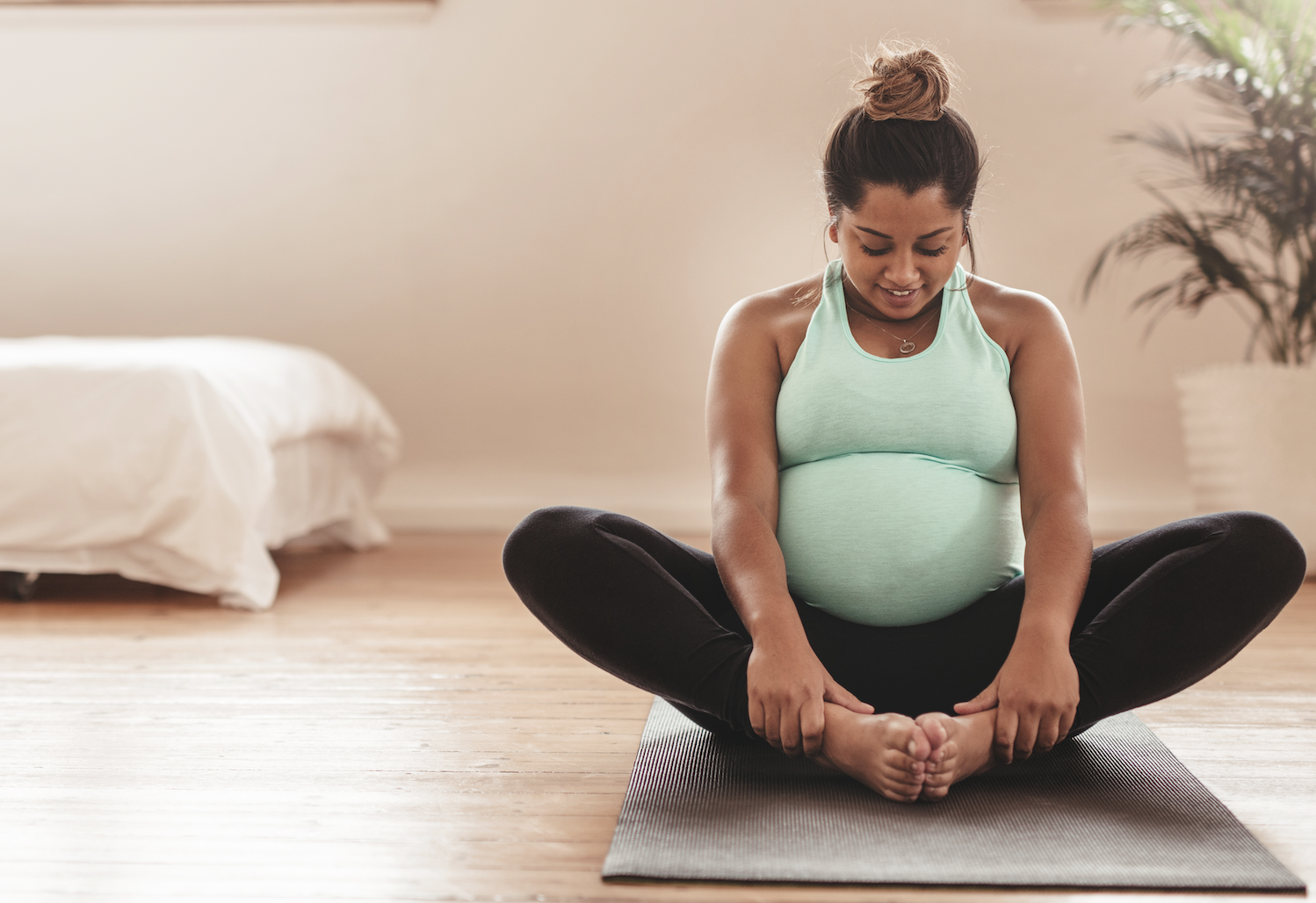 Pregnant woman stretching on the floor