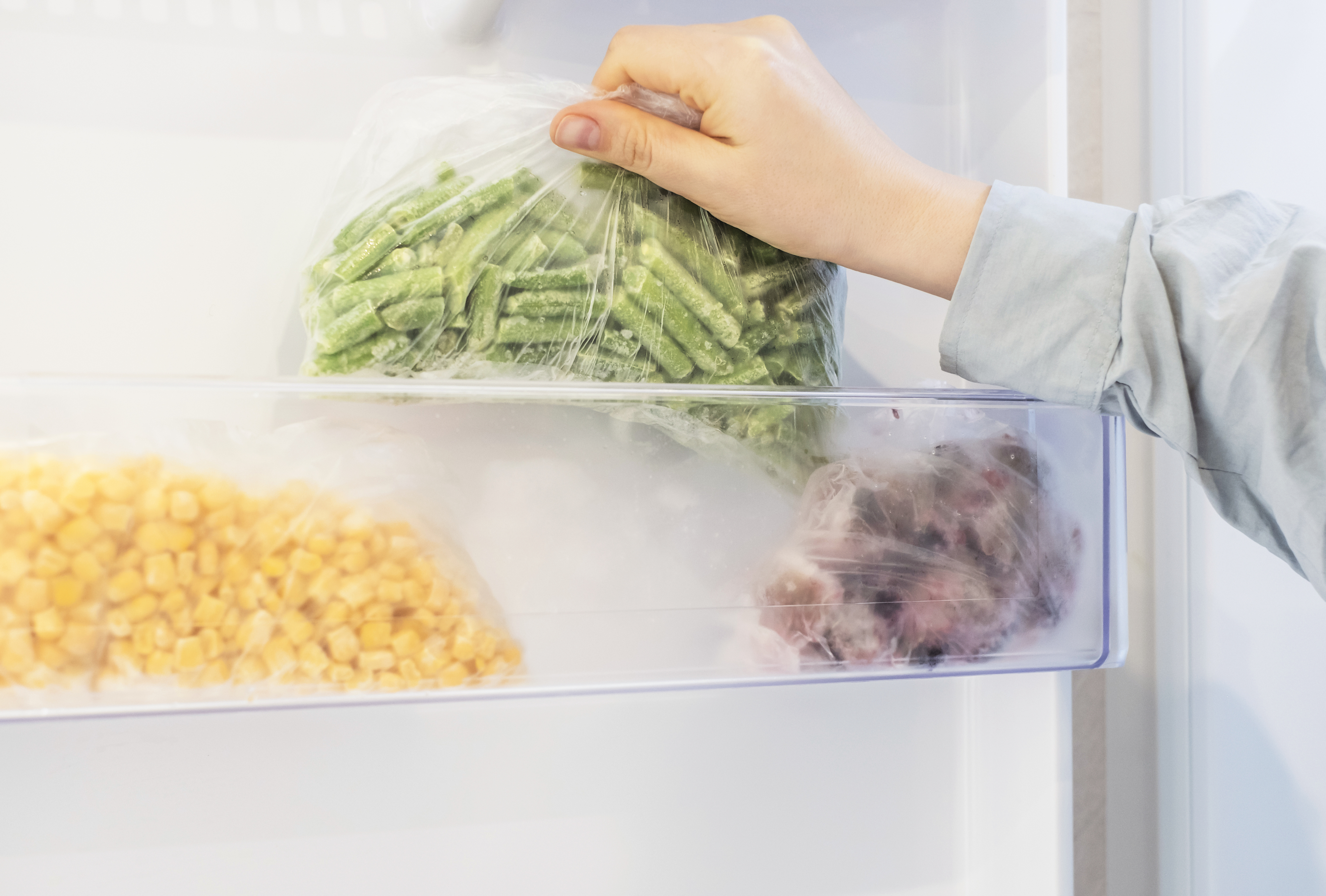 frozen vegetables on the shelf of a freezer