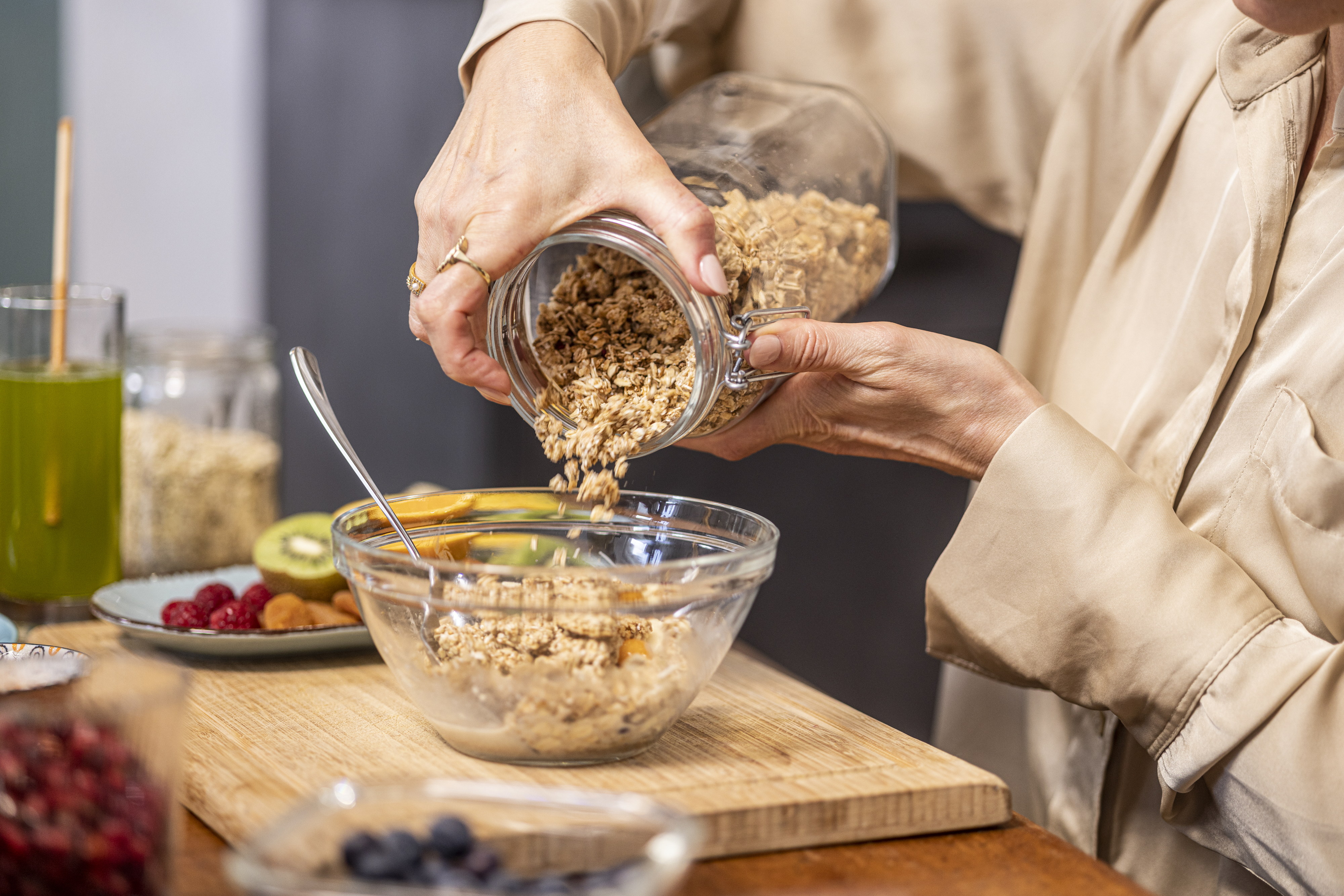 someone pouring oats into a bowl