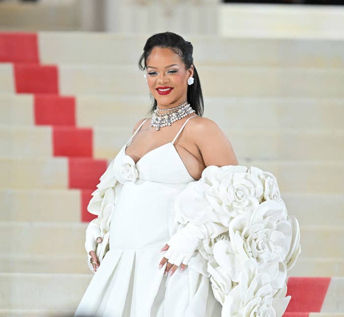 Closeup of a pregnant Rihanna smiling on the red carpet in a spaghetti-strap dress