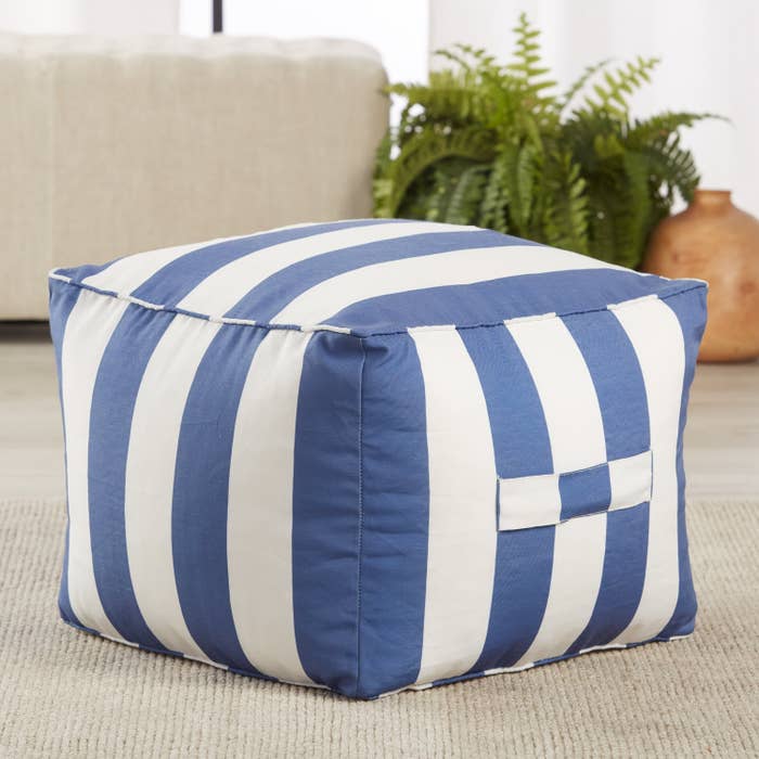 the square pouf with stripes on a patio