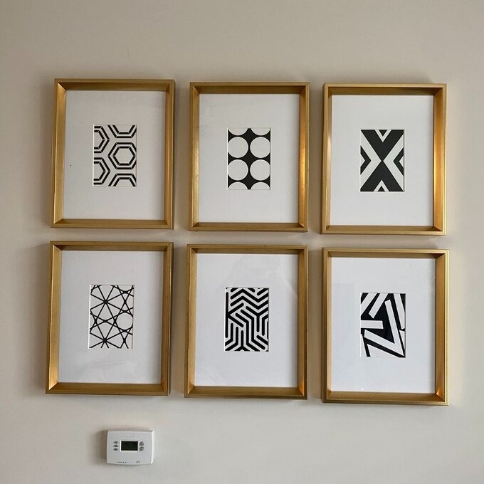 a reviewer photo of the six framed prints arranged in two rows of three on a wall