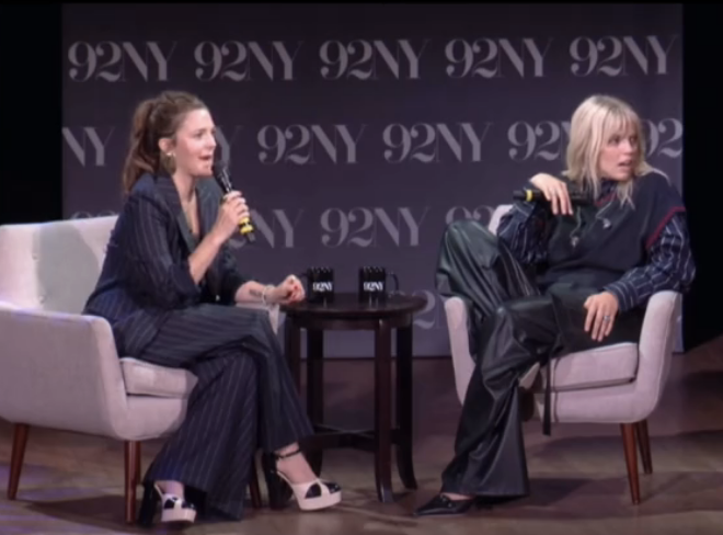 Closeup of Drew Barrymore and Reneé Rapp sitting on stage