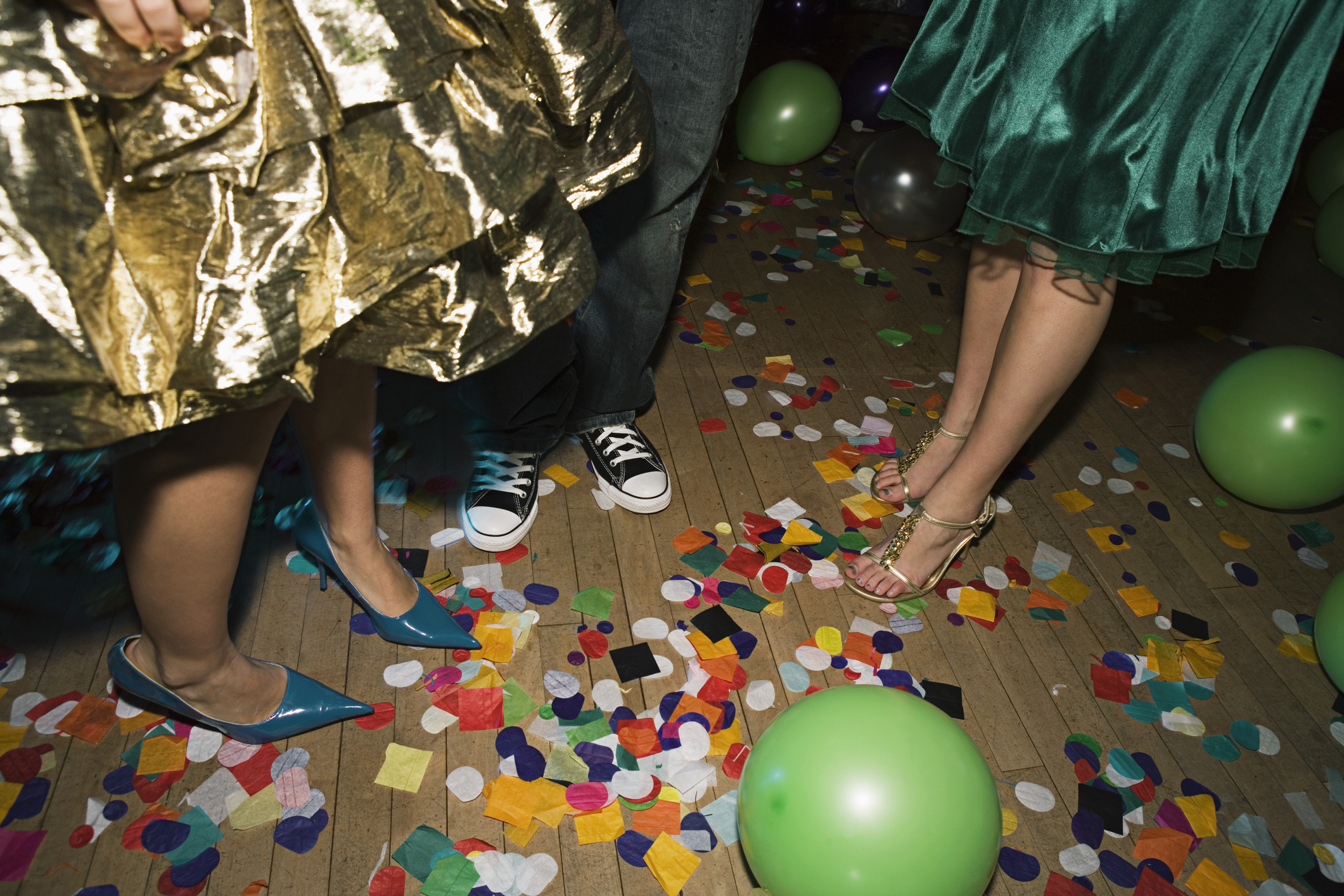 People at a party with colorful confetti and balloons on the floor