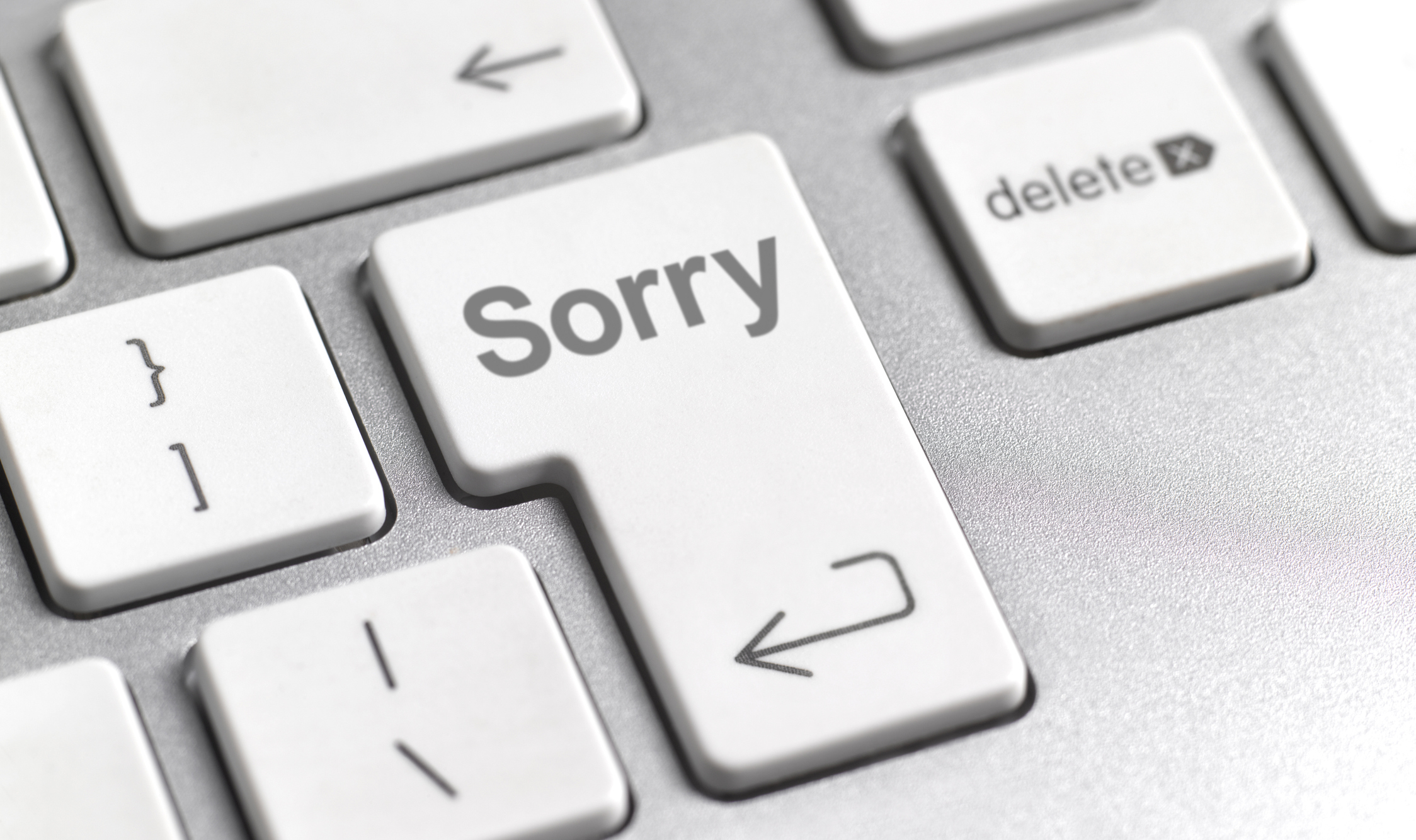 A close-up of a keyboard with the word &quot;Sorry&quot; on one key