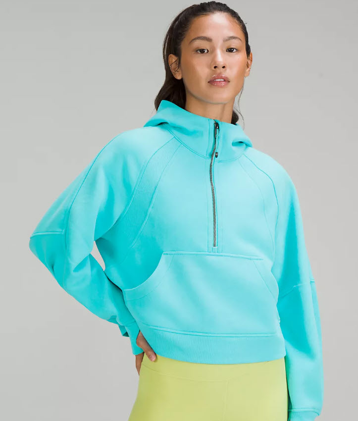 model in bright teal half zip sweater