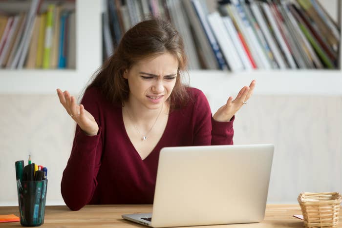 person frustrated and looking at their laptop