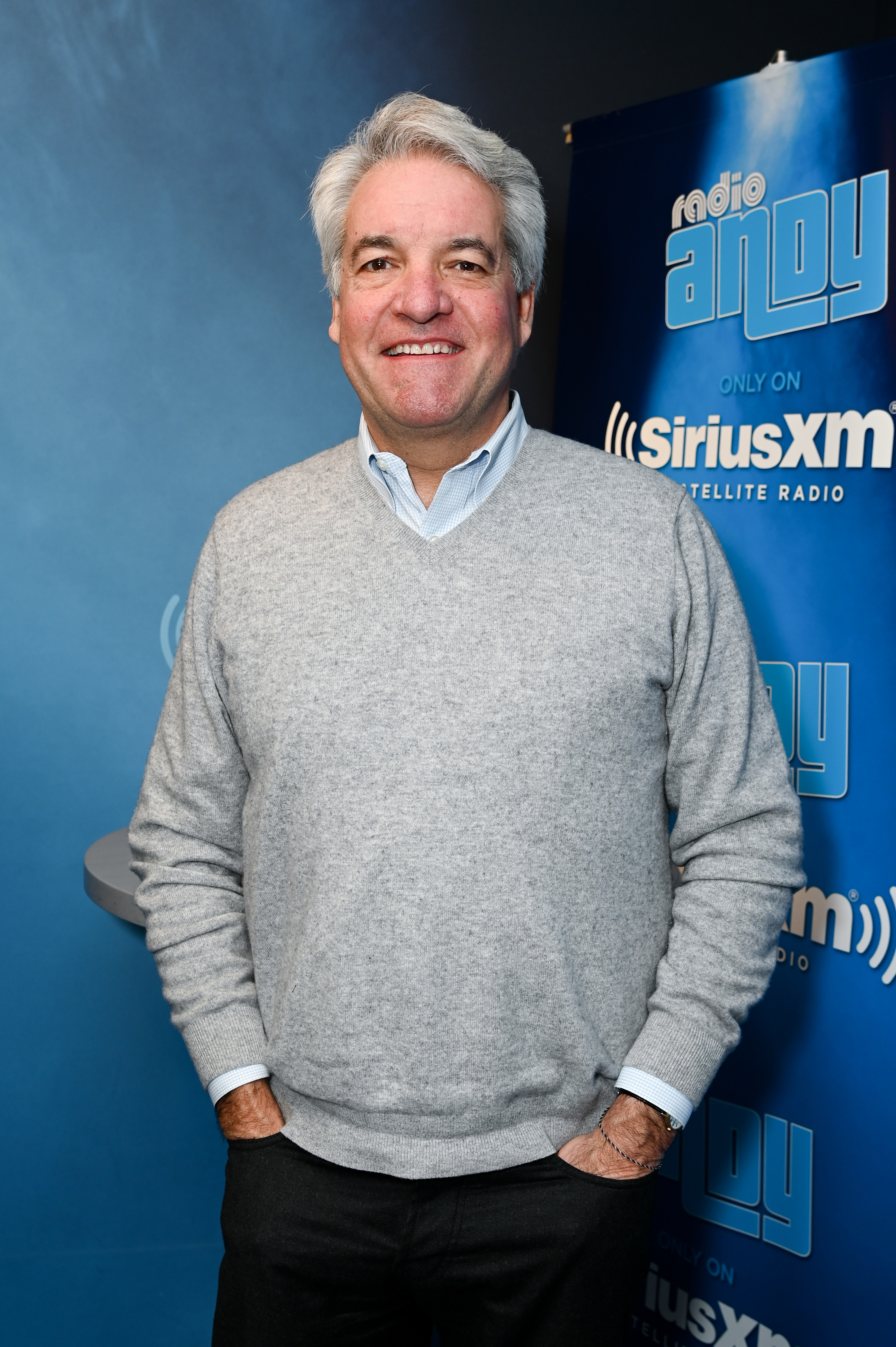 man standing in front of a sirius xm step and repeat