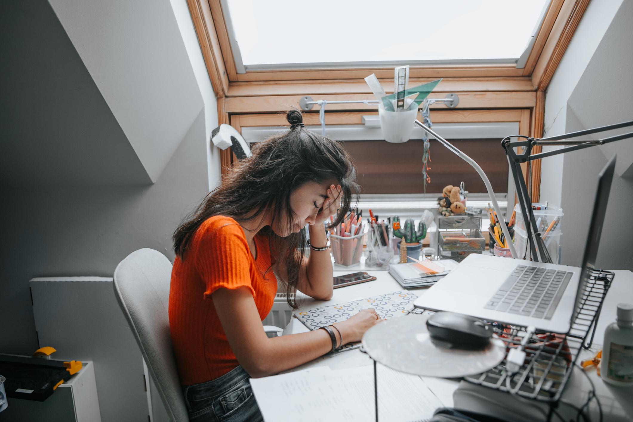 A young girl looking stressed at her desk